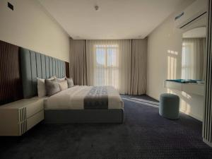 a hotel room with a bed and a large window at فيلمست ريزيدنس ابهاVelmist Residence Abha in Abha