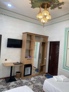 a room with a table and a desk in a room at Gavhar Boutique Hotel in Khiva