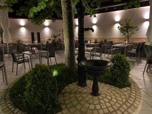 a restaurant with tables and chairs and a fountain at Hotel Adler Äpfingen in Äpfingen