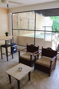 a living room with two chairs and a table at House with pool in downtown Merida, Yucatan in Mérida