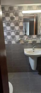 un bagno con lavandino e specchio di Highland Lodge a Karachi Altre 21 foto