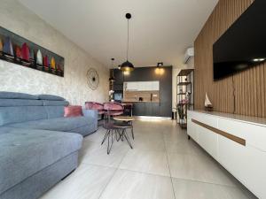 a living room with a blue couch and a table at Apartment Lapis with pool near the beach- by TA Leut Agency in Privlaka