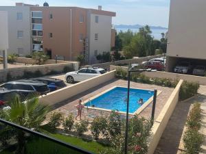 a swimming pool in the middle of a parking lot at Apartment Lapis with pool near the beach- by TA Leut Agency in Privlaka
