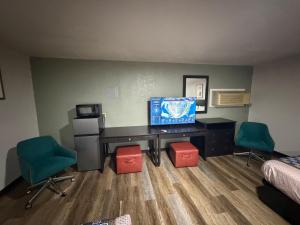 a room with a desk with a television and two chairs at Budget Inn Ada in Ada +9 photos