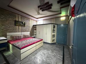 a bedroom with a bed and a blue door at UK Guest House in Chāh Mahūnwāla