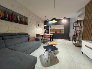 a living room with a couch and a table at Apartment Lapis with pool near the beach- by TA Leut Agency in Privlaka