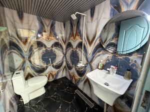 a bathroom with a sink and a toilet and a mirror at UK Guest House in Chāh Mahūnwāla +17 photos