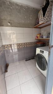 a dirty bathroom with a washing machine in it at UK Guest House in Chāh Mahūnwāla