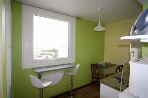 a kitchen with green walls and a window at La chouette verte in Granville