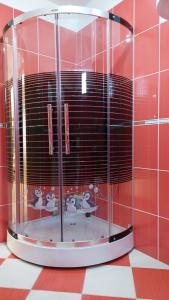a glass shower in a room with a red wall at Apartman AS na jezeru in Konjic +13 photos