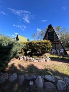 a log cabin with a stone wall in front of it at Cabañas Wencesmar in Hipólito Yrigoyen