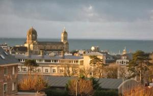 a city with buildings and the ocean in the background at La chouette verte in Granville +6 photos