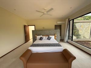a bedroom with a bed and a ceiling fan at Casa Palmyre in Rivière Noire
