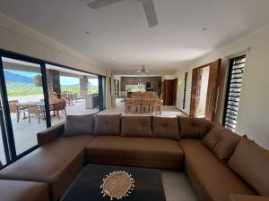a living room with a brown couch and a table at Casa Palmyre in Rivière Noire