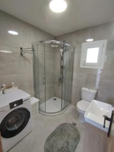 a bathroom with a shower and a washing machine at KIS Home in Loúros +26 photos