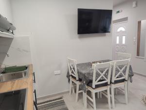 a dining room with a table and chairs and a tv at KIS Home in Loúros