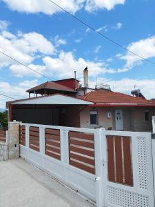 a white fence in front of a house at KIS Home in Loúros