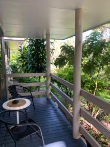 a porch with two chairs and a table at Turtle Cove Lake Front Cabin 300m To Beach in Hervey Bay