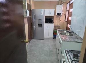 a kitchen with a refrigerator and a sink at Habitaciones Express Calama in Calama