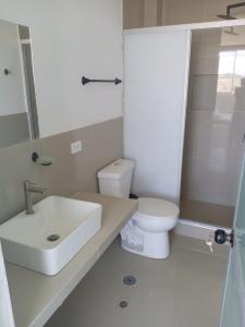 a white bathroom with a sink and a toilet at OOK Home in Canoas de Punta Sal