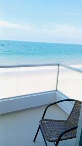 a chair sitting on a balcony overlooking the ocean at OOK Home in Canoas de Punta Sal