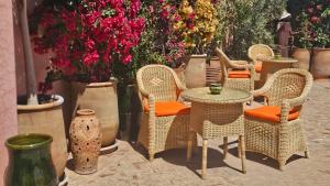 a group of wicker chairs and tables and flowers at Riad Jnane d'Ô in Marrakesh