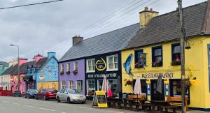 a row of colorful buildings on a city street at Grace's Landing in Sneem +17 photos