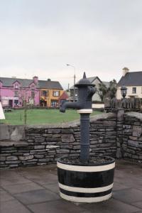 a bird bath in front of a stone wall at Grace's Landing in Sneem
