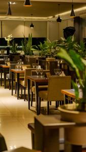 ein leeres Restaurant mit Tischen, Stühlen und Pflanzen in der Unterkunft Eleton Resort & Spa in Villa Carlos Paz