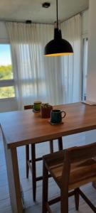 a wooden table with a chair and a lamp at Tigre a estrenar in Tigre