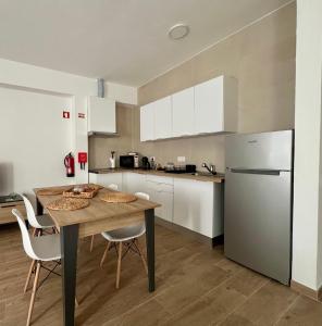 a kitchen with a table and chairs and a refrigerator at Ducal Guest House in Vila Viçosa