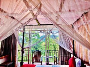 a room with a bed and a window with curtains at Ella Nature Life Guest & Restaurant -Free Pickup from Ella in Ella