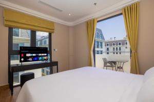 a bedroom with a bed and a large window at Grand Bay Hotel - Grand World Phu Quoc in Phú Quốc