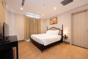 a bedroom with a bed and a flat screen tv at Grand Bay Hotel - Grand World Phu Quoc in Phú Quốc