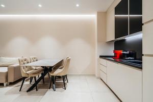 a kitchen and dining room with a table and chairs at Coastal Residences by In Property in Bečići