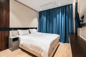 a bedroom with a large bed and blue curtains at Coastal Residences by In Property in Bečići +23 photos