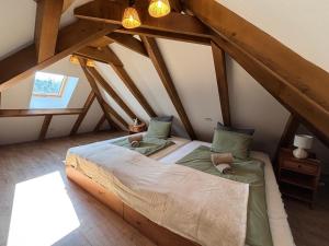 a bedroom with two beds in a attic at Erdő mellett lebzselő in Mogyoróska +24 photos