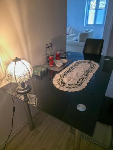 a glass table with a lamp on top of it at Weserblick Apartment Stolzenau 24h Selfcheckin in Stolzenau