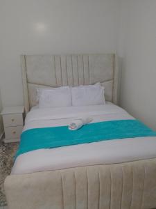 a bed with a towel on top of it at Modern staycation -ruaka in Ruaka