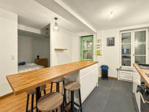 a kitchen with a wooden counter top and stools at Le Vercors in Valence +1 photo