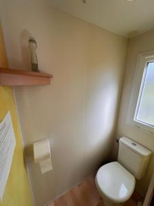 a bathroom with a white toilet and a window at Mobile Home à Louannec in Louannec +10 photos