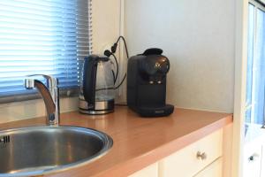 a coffee maker sitting on a counter next to a sink at Huisje Weltevree Gendt in Gendt +21 photos