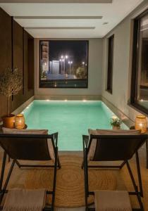 a pool in a room with two chairs and a table at Coastal Residences by In Property in Bečići