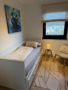 a bed in a room with a window and a chair at WohlfühlWerk L4 in Mechernich