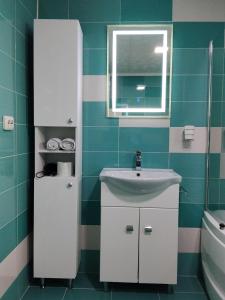 a bathroom with a white sink and a window at Casa Katiușa in Jurilovca +26 photos