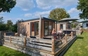 a woman standing on the deck of a tiny house at Tiny House in Kropswolde +14 photos