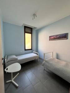 a room with two beds and a chair and a window at El Jardin in Bellano +2 photos