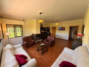a living room with two couches and a tv at VILLA LÚA in Cartaya