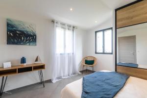 a bedroom with a bed and a desk and a chair at Casa u fornu Residence & Spa in LʼÎle-Rousse +52 photos