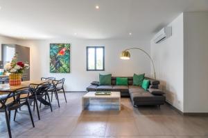 a living room with a couch and a table at Casa u fornu Residence & Spa in LʼÎle-Rousse